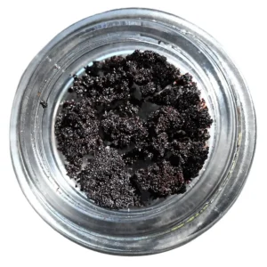 A jar with a fine dark brown crystalline substance.